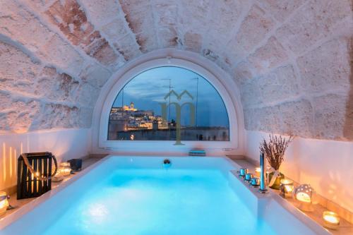 a bath tub in a room with a window at Dimora Matteotti by Meravigliosa Puglia RealEstate in Ostuni