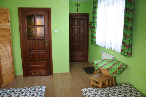 a room with green walls and a door and a chair at Pokoje Gościnne Łukaszczyk in Zakopane
