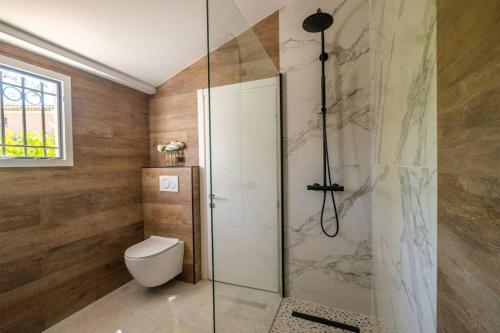 a bathroom with a toilet and a glass shower at Maisonnette de charme in La Colle-sur-Loup