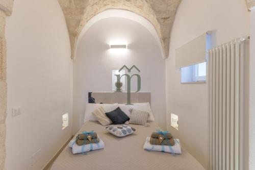 a bedroom with a bed with two pillows on it at Dimora Matteotti by Meravigliosa Puglia RealEstate in Ostuni