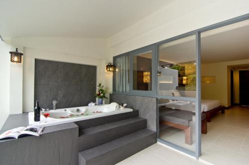 ein Badezimmer mit Badewanne und Waschbecken in der Unterkunft Sunshine Garden Resort in Pattaya North