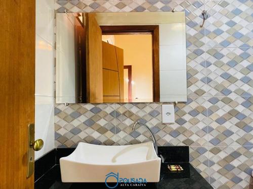 La salle de bains est pourvue d'un lavabo et d'un miroir. dans l'établissement Pousada Alta Caraíva, à Caraíva