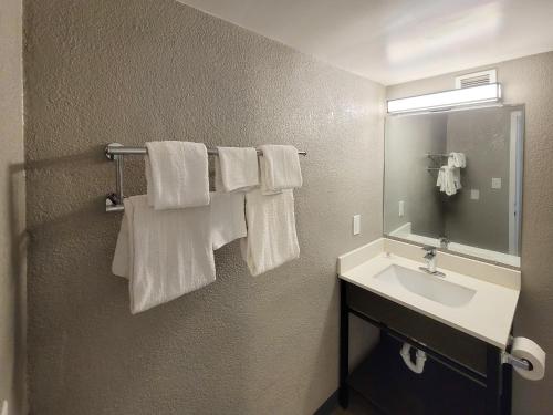a bathroom with white towels hanging on a wall at Motel 6 Jackson, TN in Jackson