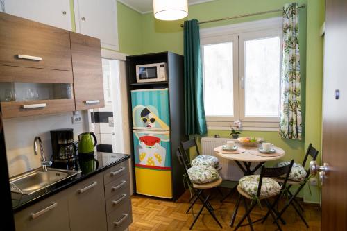 a kitchen with a small table and a refrigerator at Charming Green Studio across the National Museum in Athens