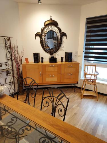 Cette chambre comprend une commode et un miroir mural. dans l'établissement Détente, à Bischwiller