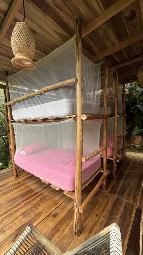 a couple of bunk beds in a wooden room at The Valley Tayrona hostel- A social jungle hostel in El Zaino