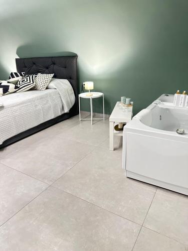 ein Schlafzimmer mit einem Bett und einer Badewanne neben einem Tisch in der Unterkunft CARMA SUITE in Neapel