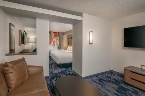 a hotel room with a bed and a flat screen tv at Fairfield Inn & Suites by Marriott Brunswick Freeport in Brunswick
