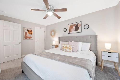 une chambre avec un lit blanc et un ventilateur de plafond dans l'établissement * Lux Modern Retreat * Downtown * King Beds *, à Durham
