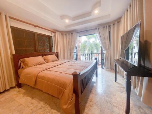 a bedroom with a bed and a flat screen tv at Patong Beach - Private Pool Villa in Patong Beach
