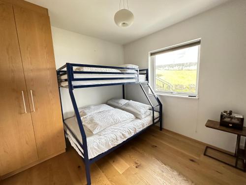 1 dormitorio con litera y ventana en Apartment in Austurkór- Birta Rentals en Reikiavik