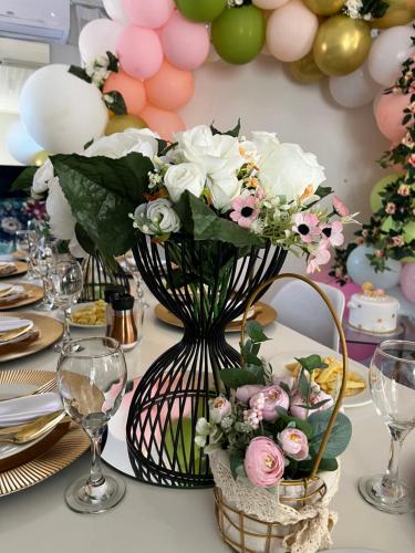 une table avec un vase de fleurs et de ballons dans l'établissement Empire Bed & Breakfast, à Leribe