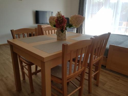 a dining room table and chairs with a vase of flowers on it at Barbora in Kašperské Hory