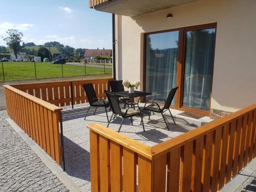a wooden deck with a table and chairs on it at Barbora in Kašperské Hory