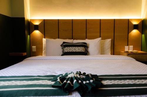 ein Schlafzimmer mit einem großen Bett mit großem Kopfteil in der Unterkunft Hotel Casona Oaxaca in Oaxaca de Juárez