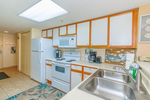 a kitchen with white appliances and a sink at Spacious Oceanfront 2 Bedroom Suite - Sleeps 8! - Roxanne Towers Unit 406 in Myrtle Beach