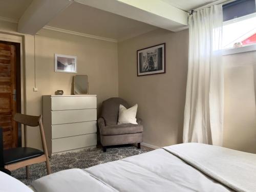 um quarto com uma cama, uma cadeira e uma cómoda em Riverfront Cosy Villa in Luleå em Luleå