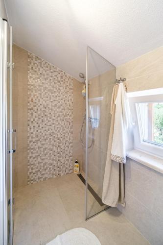 a bathroom with a shower with a glass door at Holiday Home Kuća Sunca in Sutivan