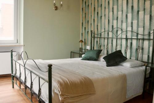 a bedroom with a large bed with green pillows at Domus 44 Rooms - Porta Nuova in Verona