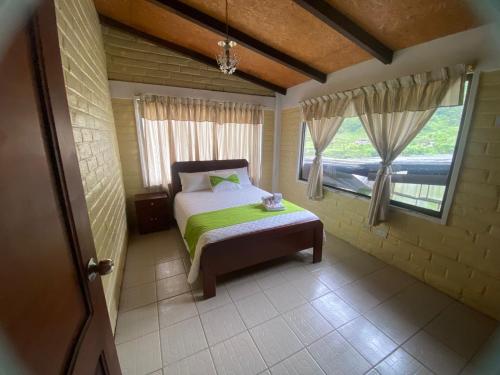 ein kleines Schlafzimmer mit einem Bett und einem Fenster in der Unterkunft Hosteria Agoyan in Baños