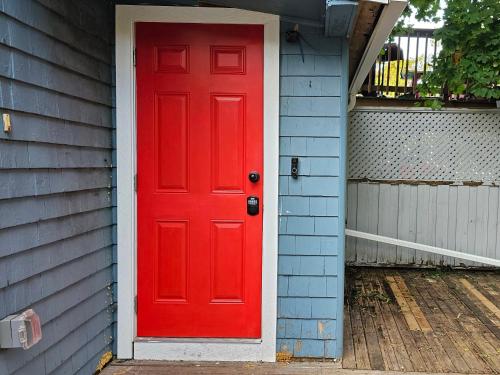 eine rote Tür an der Seite eines Hauses in der Unterkunft Serenity Getaway in Halifax