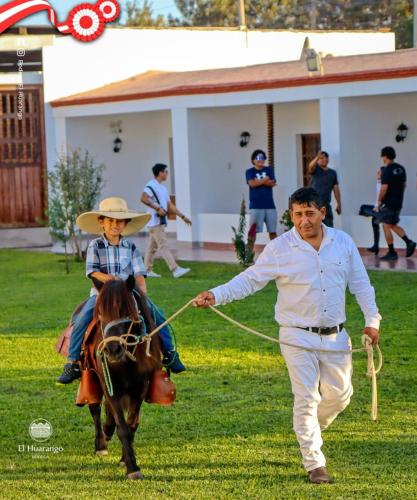 a man is leading a boy on a horse at Bodega el Huarango in Ica