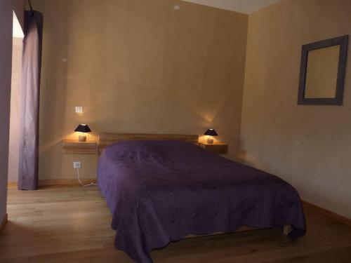 um quarto com uma cama roxa e 2 candeeiros em Gite Le Millepertuis - Proche Site Alésia em Darcey