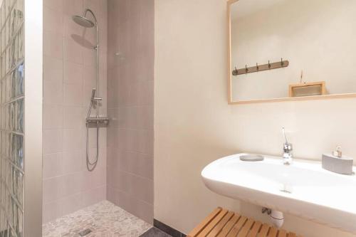 uma casa de banho branca com um lavatório e um chuveiro em Gite Le Millepertuis - Proche Site Alésia em Darcey
