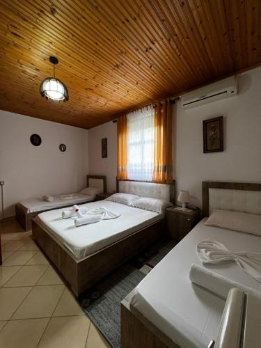 a bedroom with two beds and a wooden ceiling at Guesthouse Emiljano in Berat