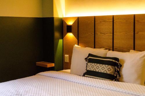 Schlafzimmer mit einem Bett mit einem schwarzen und weißen Kissen in der Unterkunft Hotel Casona Oaxaca in Oaxaca de Juárez