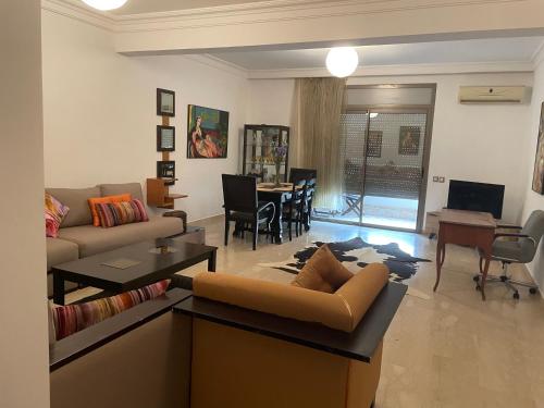 Bel appartement à skhirat plage et à 20 mn de Rabat في الصخيرات‎: غرفة معيشة مع أريكة وطاولة