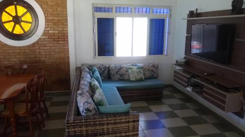 a living room with a couch and a television at Casa para finais de semana temporada in Caraguatatuba