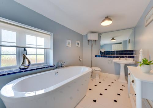 a large bathroom with a tub and a sink at The Firs in Brundall