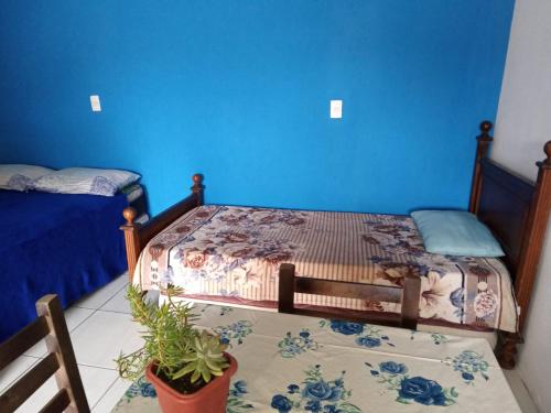 1 dormitorio con 2 camas individuales y paredes azules en Moradas Renascer 2, en Praia do Rosa