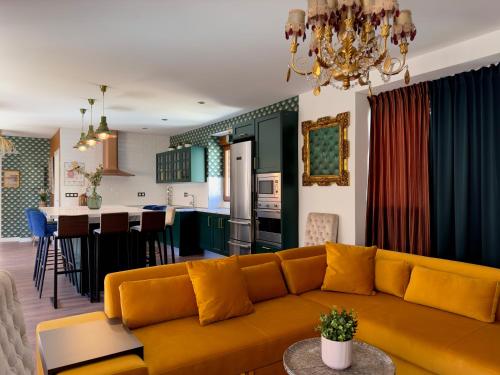 un salon avec un canapé jaune et une cuisine dans l'établissement Libelle Andalusian Hideaway C, à Grenade
