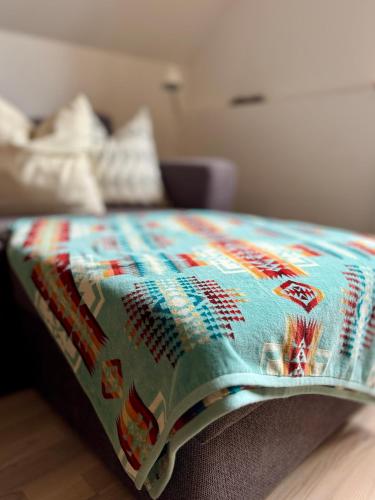 a bed with a colorful blanket on top of it at Kåseberga Hideout in Kåseberga
