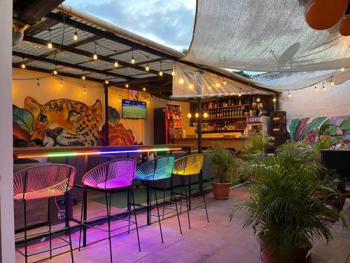 a bar with colorful chairs and a counter in a room at Hotel y Restaurante San Fernando. in Jocotenango