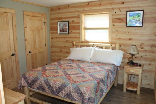 a bedroom with a bed with a wooden wall at Vista Lodge Benton PA near Ricketts Glen State Park in Benton