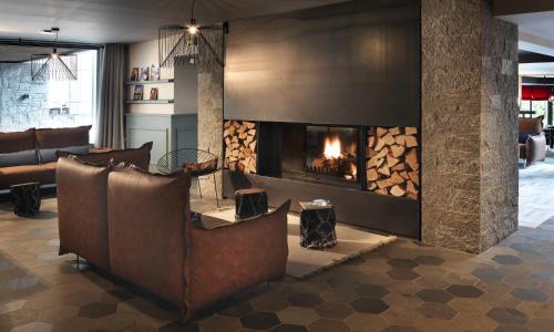 a living room with a fireplace and a couch at Chalet Hôtel Le Prieuré & Spa in Chamonix-Mont-Blanc