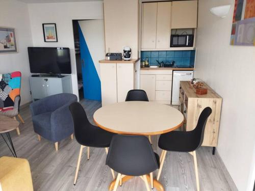 uma cozinha com mesa e cadeiras num quarto em Studio au cœur de Quiberon em Quiberon