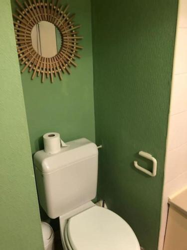 a bathroom with a white toilet and a mirror at Studio au cœur de Quiberon in Quiberon