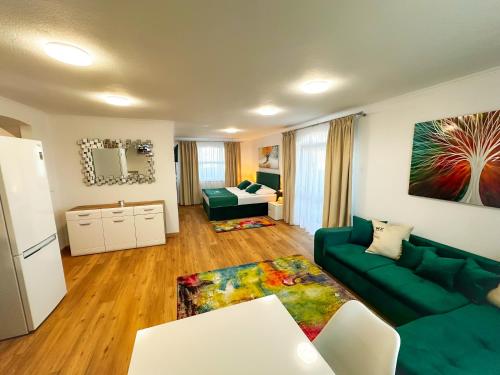a living room with a green couch and a table at WX Hotel in Bratislava