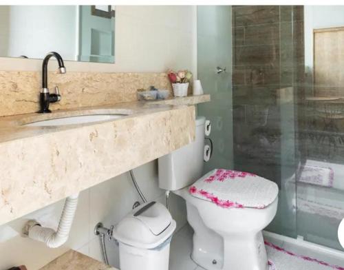 a bathroom with a toilet and a sink and a shower at Chalé aconchegante próximo ao aeroporto in São José dos Pinhais