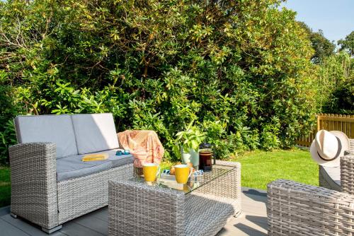 two wicker chairs and a table on a patio at Luxury Country Cottage, near Tavistock. in Tavistock