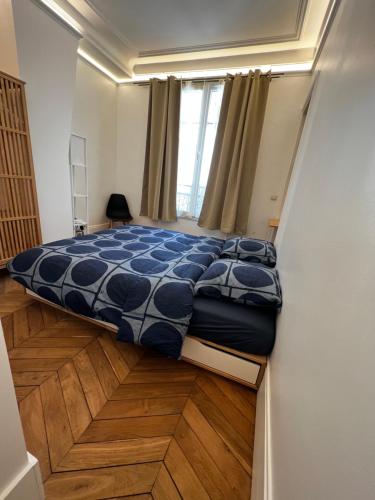 a bedroom with a bed with a blue comforter at Sweet-cosy apartment Near république place in Paris