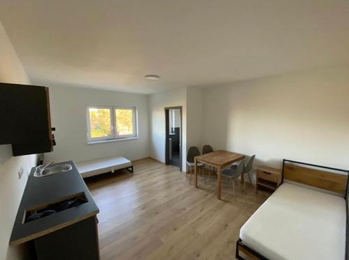 a room with a bed and a desk and a table at Zimmer mit Bad und Küche in Rötgesbüttel