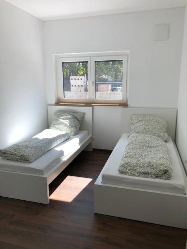 2 camas en una habitación con 2 ventanas en Schöne Wohnung in Schwaigern en Schwaigern
