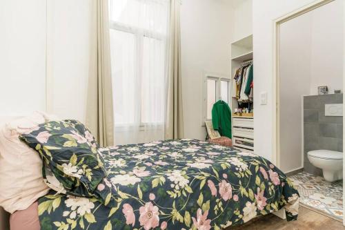een slaapkamer met een bed met een bloemdekbed bij Duplex en plein centre historique Aix en provence in Aix-en-Provence