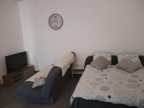 un salon avec un canapé et une horloge au mur dans l'établissement Studio, à Arles