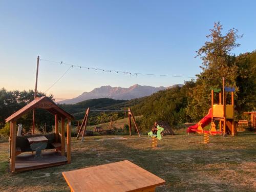 a playground with a swing set and a table at Lo Scoiattolo Country House in Montorio al Vomano